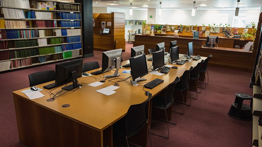 Desk with computers on in a school library.